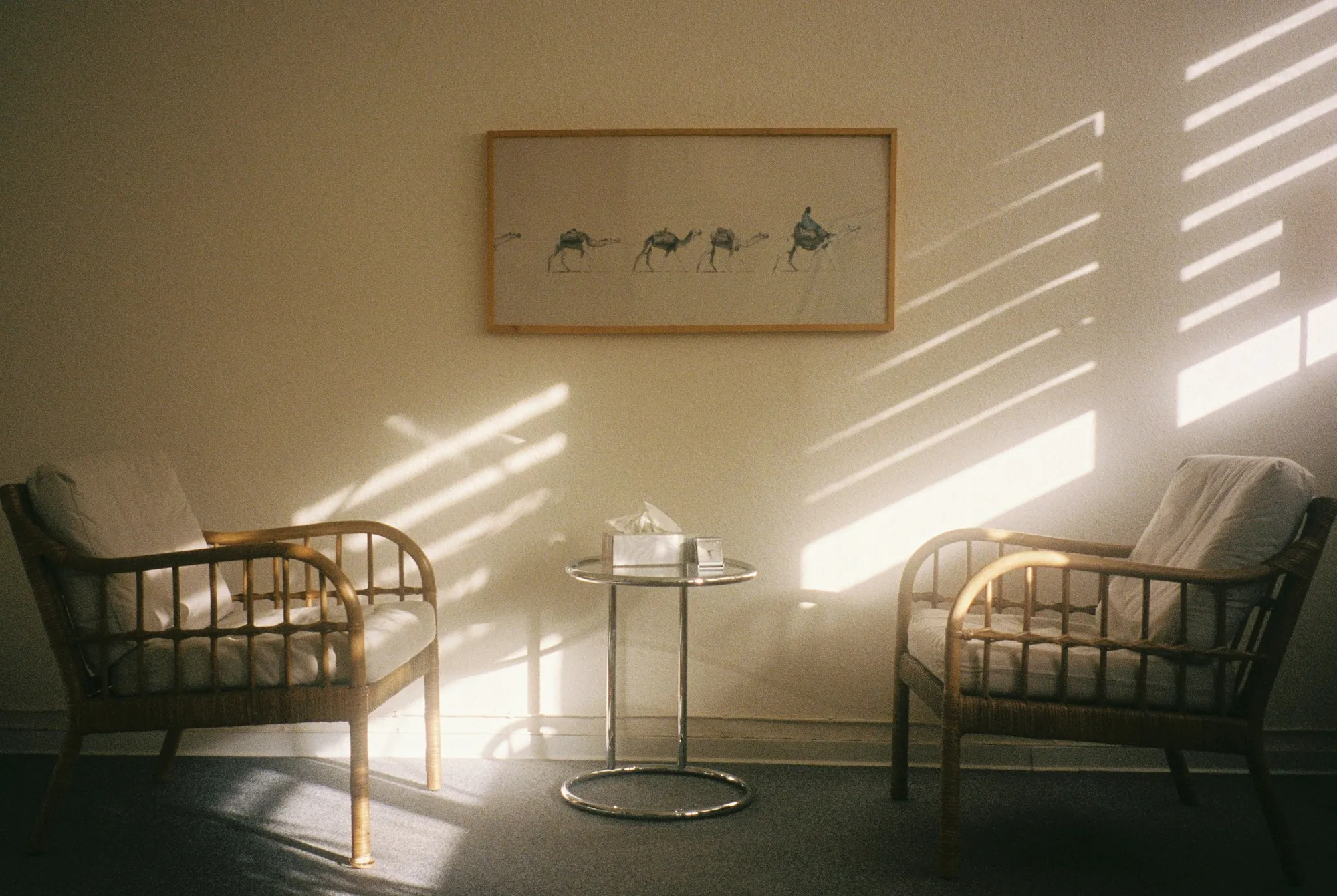 Two armchairs facing each other in a therapy room, in warm light from the window